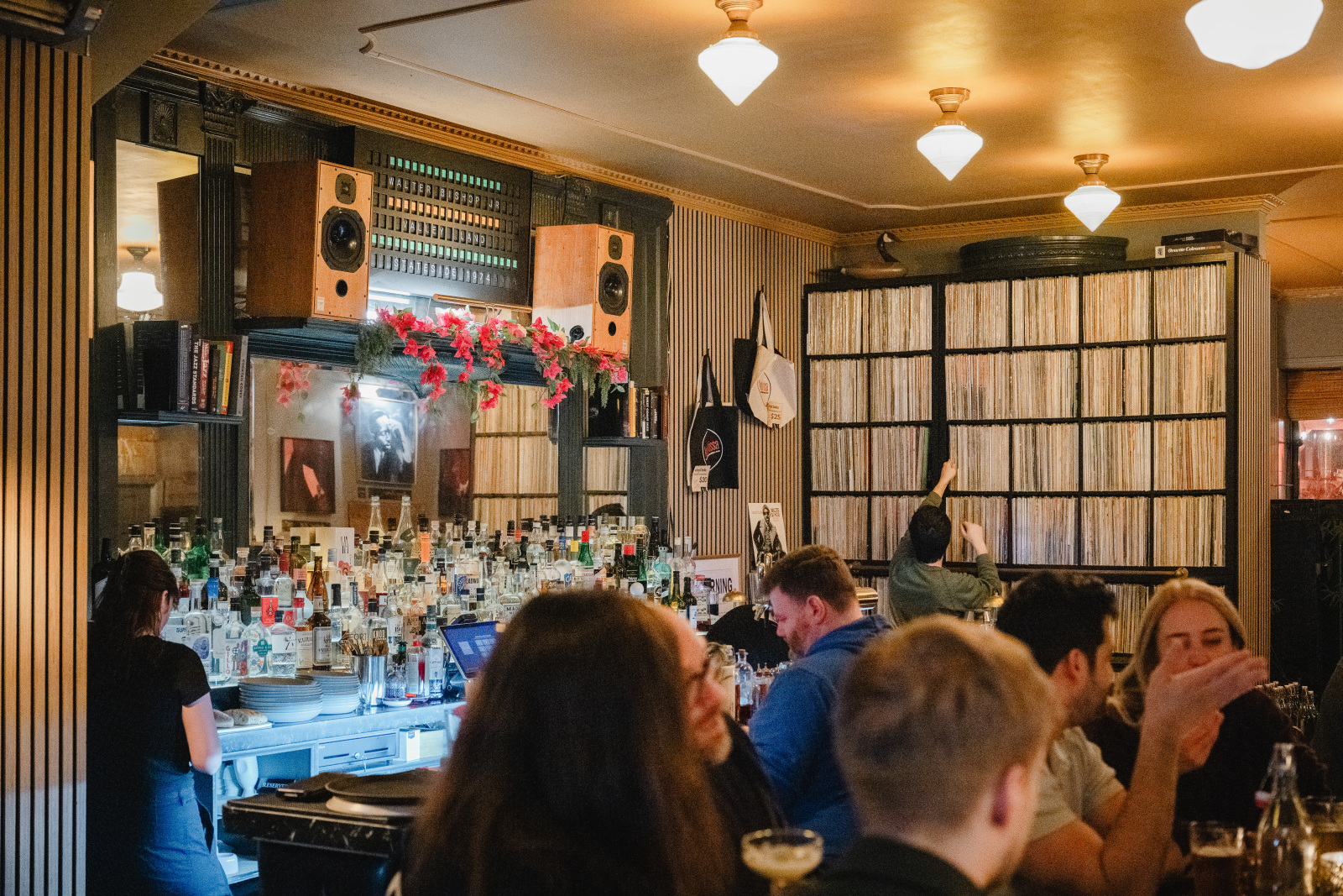 Bartender selecting a vinyl record from the jazz collection at Kissa Kissa — curated listening bar experience in Crown Heights Brooklyn