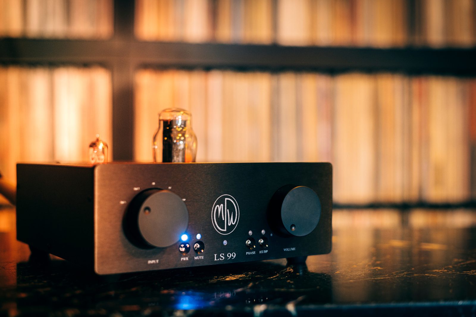 ModWright LS 99 tube preamplifier with a glowing tube in front of the record wall at Kissa Kissa